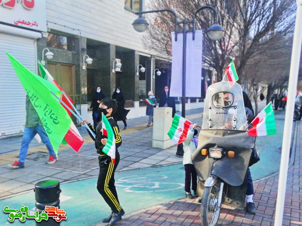 آماده شدن مردم در خیابان های اطراف محل شروع رژه برای جشن پیروزی انقلاب